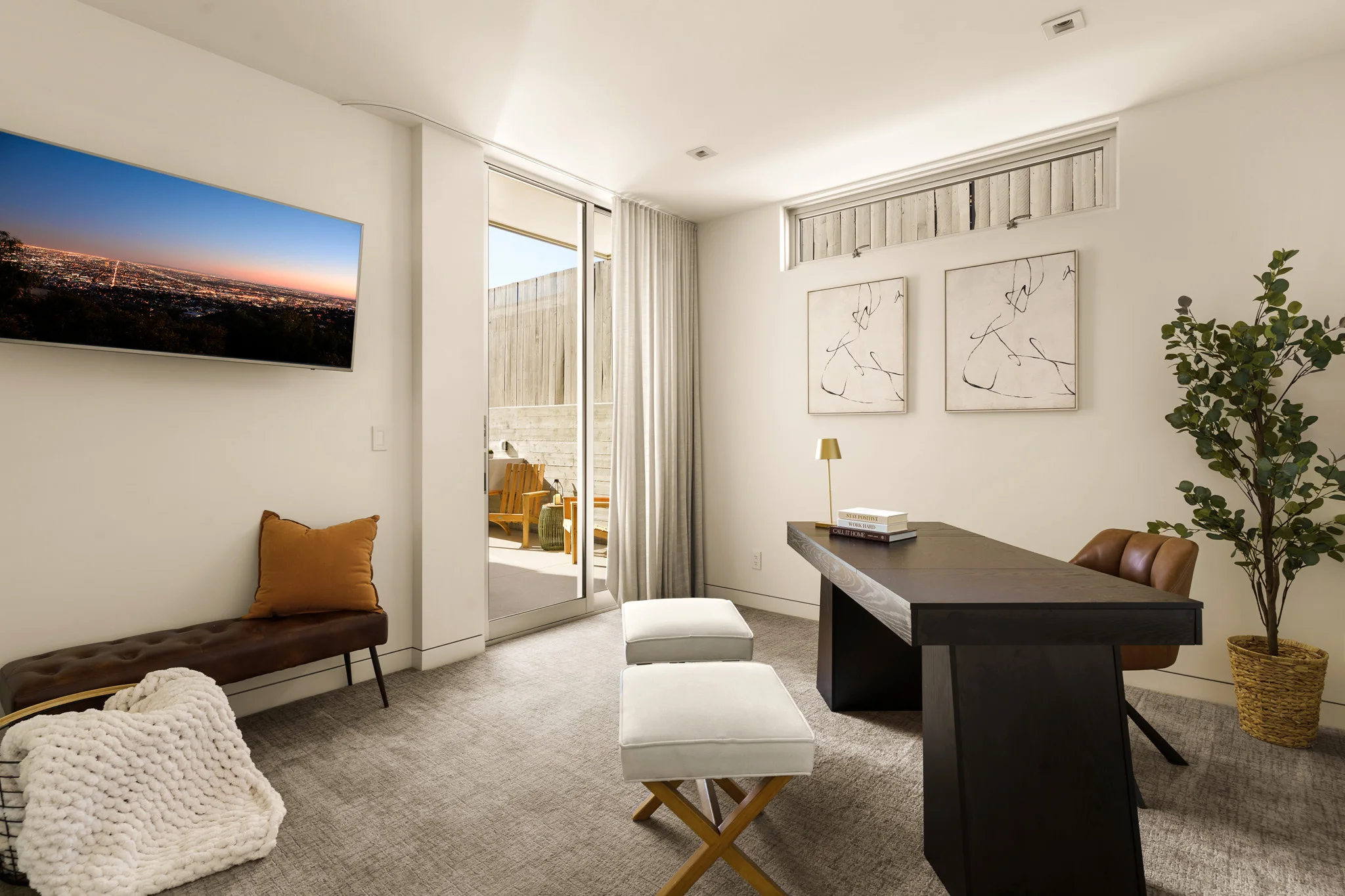 Study with a blackened-oak desk, leather bench and a long horizon photograph on the wall
