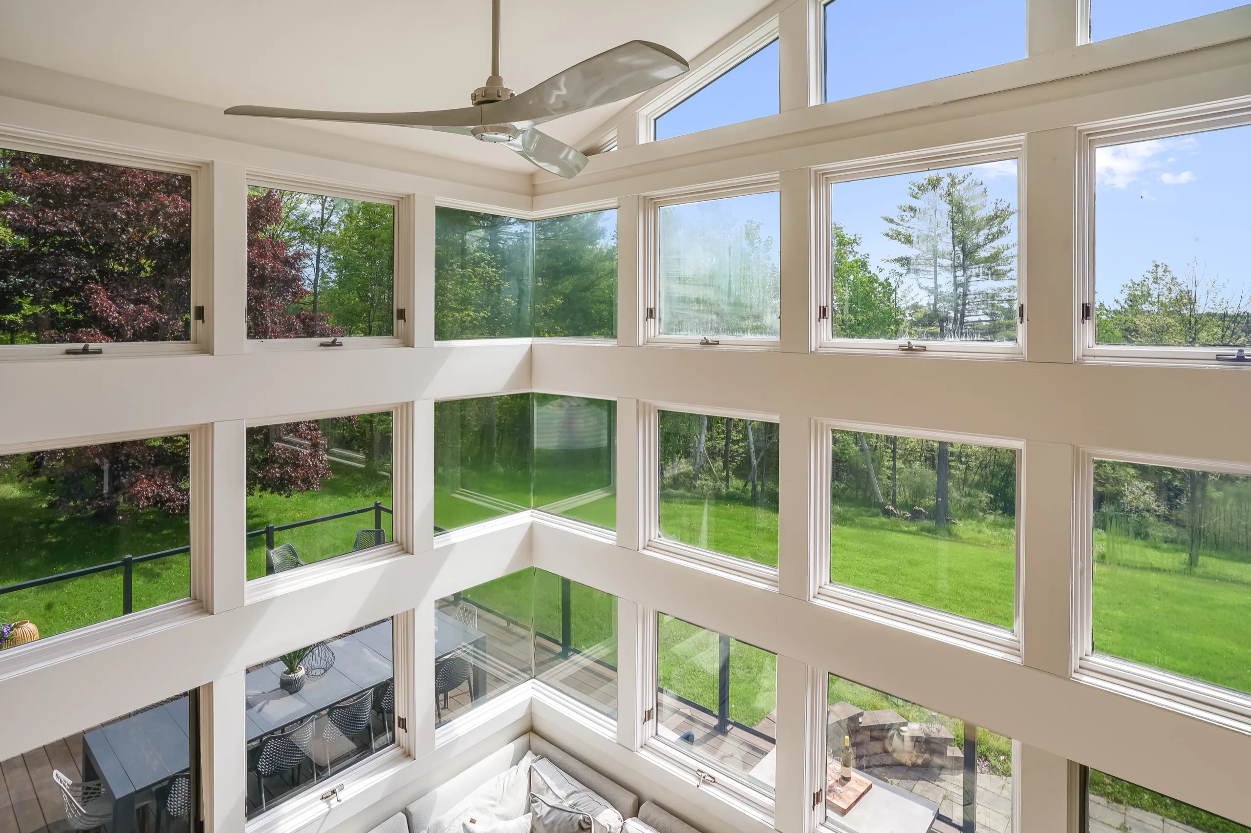The window wall from the upper landing, glazing turning the corner high above the lawn